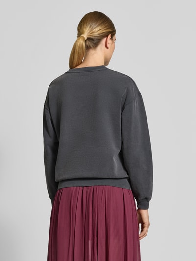 Vrouwenmodel draagt Oversized Sweatshirt aus reiner Baumwoll van Anine Bing in donkergrijs met elastische boordjes, ruglengte 52 cm, Ganzkörperansicht Rückansicht.
