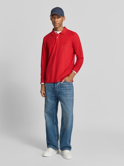 Männermodel trägt Regular Fit Langarm-Poloshirt mit Label-Stitching von Fynch-Hatton in Rot, reine Baumwolle, Knopfleiste, Ganzkörperansicht von vorne.