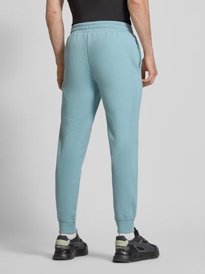 Männermodel trägt Sweatpants mit elastischem Bund von PUMA PERFORMANCE in Hellblau, Baumwoll-Mix, Label-Stitching, Ganzkörperansicht Rückansicht.
