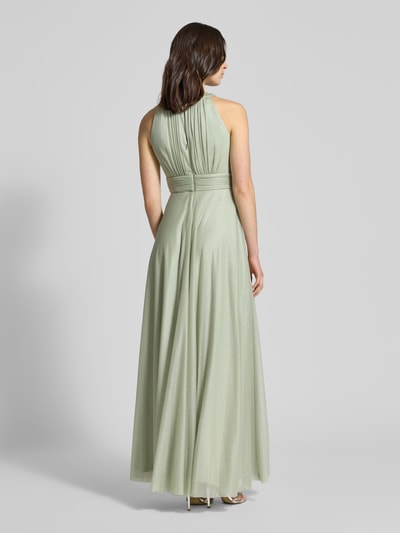 Frauenmodel trägt Regular Fit Abendkleid aus Glitzer-Mesh von Jake*s Cocktail in zartem Grün mit Schlüssellochausschnitt, Falten-Optik, taillierter Passform und Nahtreißverschluss, Rückenlänge bei Größe 36: 152 cm, Brustweite: 37 cm, Ganzkörperansicht Rückansicht.