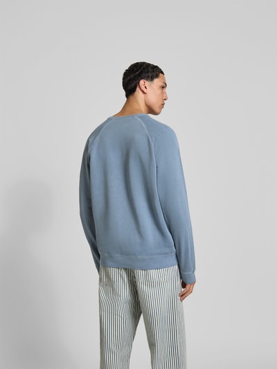 Männermodel trägt Relaxed Fit Sweatshirt aus Baumwolle von Closed in Hellblau mit Raglanärmel, elastischen Abschlüssen, Rückenansicht.
