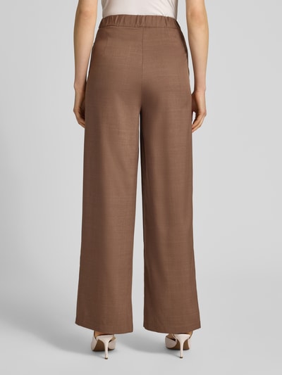 Frauenmodel trägt Stoffhose mit gelegten Falten von Little Mistress in Braun, Wide Leg, glatte Textur, Ganzkörperansicht Rückansicht.