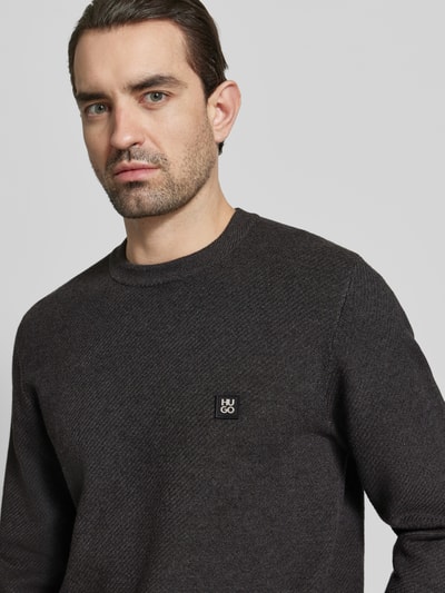 Männermodel trägt Regular Fit Pullover mit Schurwoll-Anteil Modell 'SETAL' von HUGO, Optik: Unifarben, Materialverarbeitung: Piqué, Nahaufnahme Oberkörper.
