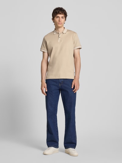 Männermodel trägt Slim Fit Poloshirt mit Strukturmuster Modell 'FABLE' von Blend in Beige, Reine Baumwolle, Knopfleiste, Ganzkörperansicht von vorne. Rückenlänge bei Größe M: 69 cm.