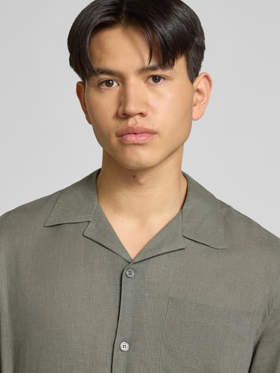 Männermodel trägt Relaxed Fit Freizeithemd aus Leinen-Viskose-Mix Modell 'LAURENCE' von Only & Sons, Optik: Unifarben, Reverskragen, einreihige Knopfleiste, Kurzarm, Brusttasche, Nahaufnahme Oberkörper.