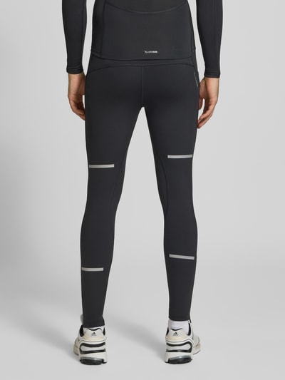 Männermodel trägt schwarze Slim Fit Trainingshose mit reflektierenden Details Modell 'adi' von adidas, adidas Training, Ganzkörperansicht Rückansicht