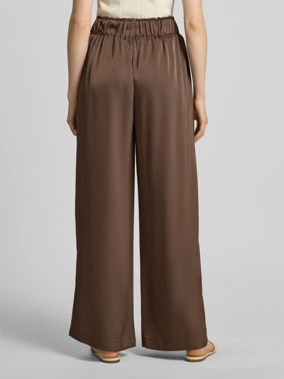 Frauenmodel trägt Wide Leg Stoffhose aus Baumwoll-Mix Modell 'LUCA' von VILLA SOPHIE, Optik: Unifarben, Passform: Wide Leg, Applikation: Label-Patch, Bundabschluss: elastisch, Taschen: seitliche Eingrifftaschen, Ganzkörperansicht Rückansicht.
