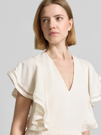 Frauenmodel trägt Fit and Flare Freizeitkleid aus Leinen-Viskose-Mix von Tommy Hilfiger in Creme mit Volantärmeln, Nahaufnahme Oberkörper.