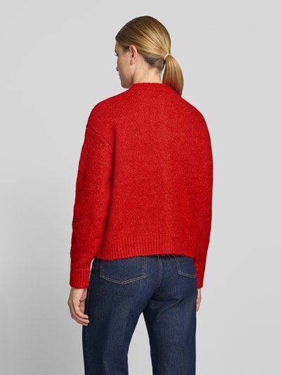 Frauenmodel trägt Relaxed Fit Strickjacke mit Woll-Anteil Modell 'Belablue' von ICHI in Rot, lockerer Schnitt, gerippte Bündchen, Ganzkörperansicht Rückansicht.