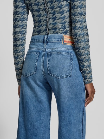 Frauenmodel trägt Wide Fit Jeans mit 5-Pocket-Design von Diesel in Hellblau, Reine Baumwolle, Lockerer-Schnitt, Label-Detail, Ganzkörperansicht Rückansicht.