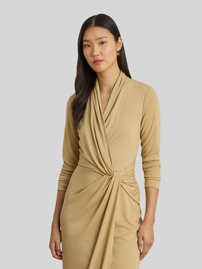 Frauenmodel trägt knielanges Kleid in Wickeloptik von Lauren Ralph Lauren, unifarben, eng anliegend, langarm, Nahaufnahme Oberkörper.