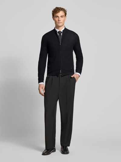 Männermodel trägt Regular Fit Strickjacke aus reiner Schurwolle von Emporio Armani, Schwarz, Zwei-Wege-Reißverschluss, Ganzkörperansicht von vorne.