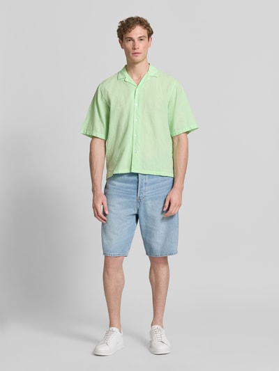 Männermodel trägt Cropped Freizeithemd aus Leinen-Baumwoll-Mix von Lindbergh in Hellgrün, Kombi aus Reverskragen, Knopfleiste, Ganzkörperansicht von vorne.