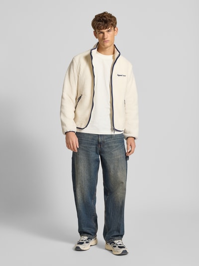 Mężczyznamodel nosi Teddyjacke mit Label-Stitching Modell 'NORREBRO' od Jack & Jones, krój regular fit, kremowy, suwak, kieszenie, napis, widok całej sylwetki z przodu, długość pleców w rozmiarze M 66 cm, szerokość ramion w rozmiarze M 46 cm, szerokość klatki piersiowej w rozmiarze M 52 cm, długość rękawa w rozmiarze M 64 cm.