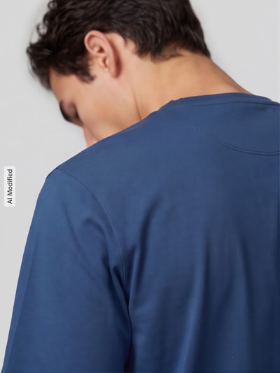 Männermodel trägt T-Shirt mit Label-Stitching und Rundhalsausschnitt von Scotch & Soda in Blau, reine Baumwolle, Regular Fit, Rückenlänge 71 cm, Ganzkörperansicht Rückansicht, KI-modifiziertes Bild.