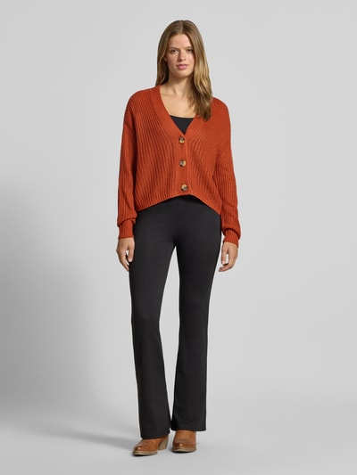 Vrouwenmodel draagt boxy fit gebreid jack met v-hals model 'CAROL' van ONLY in roestoranje, ribstructuur, Dames gebreid jack, volledige lichaamsvooraanzicht
