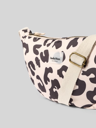 Produktfoto, Fanny Pack mit Logo-Detail von Studio Noos im Allover-Animal-Print, cremefarbene Basis mit schwarzen Formen, Reißverschluss und verstellbarem Schulterriemen, Struktur aus weichem Stoff, Maße 40 x 20 x 11 cm, Schulterriemenlänge 65 cm