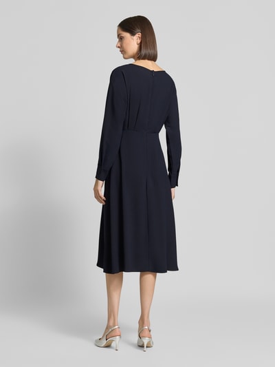 Frauenmodel trägt Midikleid mit Rundhalsausschnitt von Christian Berg Woman Selection in Dunkelblau, A-Linie, Rückansicht, Ganzkörperansicht von hinten. Rückseitiger Reißverschluss, Teilungsnaht, lange Ärmel, Kontext: Rückenlänge 110 cm, Brustweite 39 cm, Ärmellänge 62 cm Größe 36.
