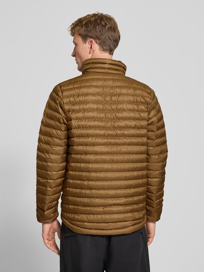 Männermodel trägt Steppjacke mit Label-Print von Helly Hansen in Braun mit Stehkragen und elastischen Abschlüssen, Ganzkörperansicht Rückansicht. Rückenlänge 72 cm, Schulterbreite 42 cm, Brustweite 54 cm, Ärmellänge 72 cm.