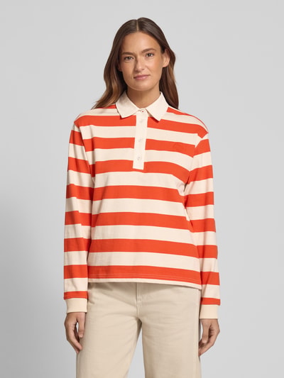 Frauenmodel trägt Longsleeve mit Label-Stitching von Jake*s Casual aus reiner Baumwolle, Regular-Fit, Polokragen, beige-rote Streifen, kurze Knopfleiste, Rückenlänge bei Größe S 23 cm, Ganzkörperansicht von vorne.