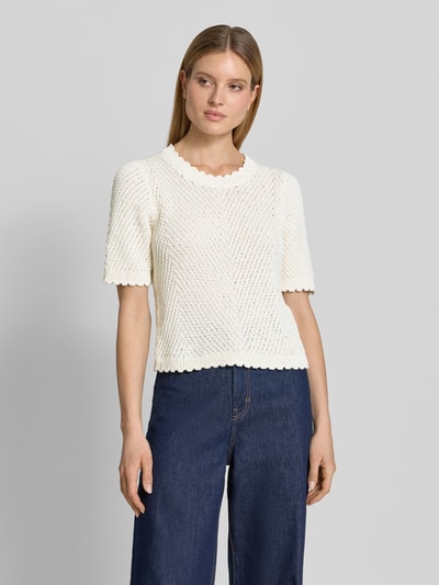 Modelka nosi Strickshirt mit 1/2-Arm Modell 'Carla' von mbyM, mieszanka bawełny, gruby ścieg, prosty krój, okrągły dekolt, długość tyłu 54 cm, długość rękawów 32 cm, jasny kolor, widok całej sylwetki z przodu.