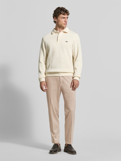 Männermodel trägt Regular Fit Hose aus Viskose-Mix Modell 'CIJUNO-O' von CINQUE in Beige mit Bundfalten und Knopfverschluss, Ganzkörperansicht von vorne.
