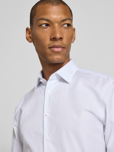 Männermodel trägt Slim Fit Businesshemd in Premiumqualität von Jake*s in Weiß mit feinen Streifen, Nahaufnahme Oberkörper.