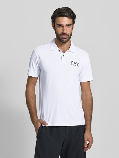 Männermodel trägt Regular Fit Poloshirt mit Logo von EA7 Emporio Armani, weiß, Material-Mix mit Stretch-Anteil, Polokragen, Knopfleiste, Ganzkörperansicht von vorne.