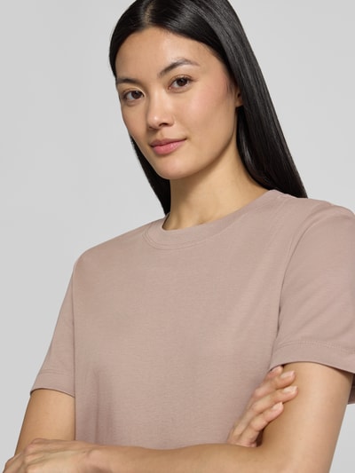 Vrouwenmodel draagt Regular Fit t-shirt van puur katoen van s.Oliver RED LABEL in lichtbeige, zachte stof, eenvoudige naden, close-up bovenlichaam.