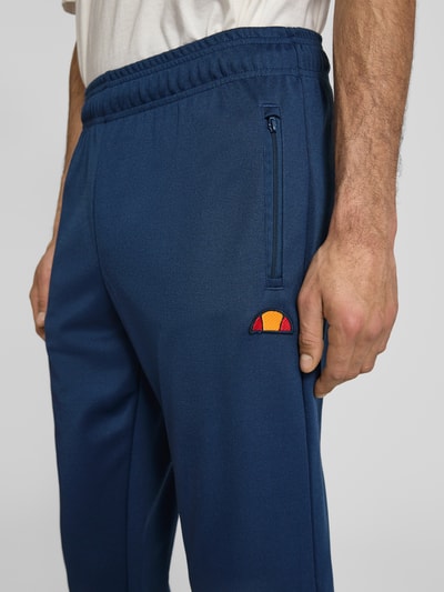 Männermodel trägt Sweatpants mit elastischem Bund Modell 'BERTONI' von Ellesse aus Baumwoll-Mix, Regular-Fit, Label-Detail, Nahaufnahme Oberkörper.