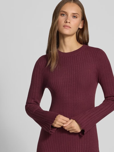Frauenmodel trägt eng anliegendes Freizeitkleid aus Viskose-Mix Modell 'MICHELLA' von ONLY in Dunkelrot, gerippte Textur, Nahaufnahme Oberkörper, Damen Strickkleid von ONLY.