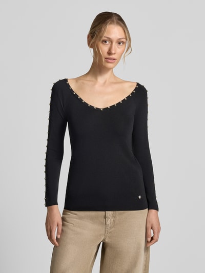 Frauenmodel trägt Slim Fit Longsleeve aus Viskose-Mix Modell 'Maglia Chiusa' von Liu Jo White in Schwarz mit Ziersteinbesatz, Nahaufnahme Oberkörper. Damen Longsleeve von Liu Jo White, V-Ausschnitt, Rückenlänge 54 cm, Ärmellänge 50 cm.