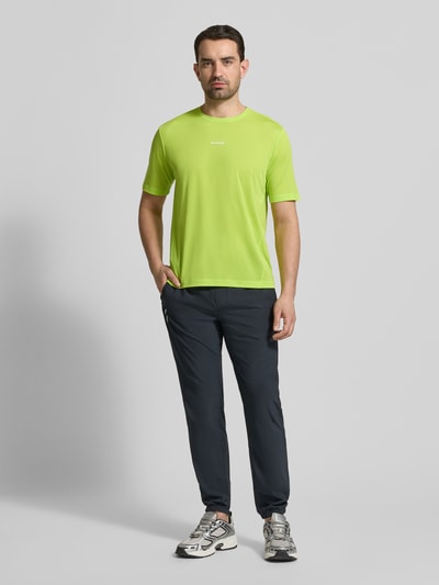 Männermodel trägt Funktionsshirt mit Rundhalsausschnitt und Logo van Salomon, regular fit, felgroen, logo op borst, vooraanzicht hele lichaam
