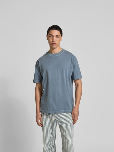 Männermodel trägt Regular Fit T-Shirt aus reiner Baumwolle von Closed, blaue Farbe, Used-Look, Label-Print, Ganzkörperansicht von vorne.