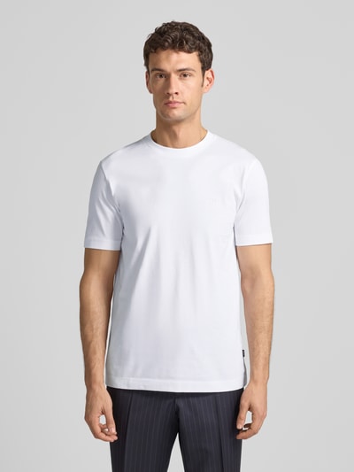 Männermodel trägt T-Shirt aus Baumwolle Modell 'Thompson' von BOSS, rechte pasvorm, wit, geribde ronde hals, logo-print, Ganzkörperansicht von vorne.