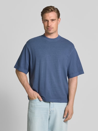 Männermodel trägt Boxy Fit T-Shirt aus reiner Baumwolle Modell 'CORY' von Selected Homme in Blau, lockere Passform, Ganzkörperansicht von vorne. Herren T-Shirt von Selected Homme