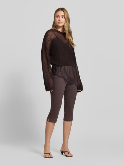 Frauenmodel trägt sommerlichen cropped Strickpullover - curated by Mary Braun von Style Icon Collection in Strick-Optik, Relaxed-Fit, mit Rundhalsausschnitt und elastischen Abschlüssen, Rückenlänge bei Größe S: 53 cm, Ärmellänge: 72 cm, dunkle Töne, lockere Struktur, Ganzkörperansicht von vorne.