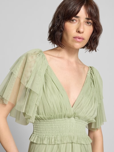 Modelka kobieca nosi sukienkę midi z szyfonu o linii a z dekoltem w serek, rękawami-motylkami i marszczonym detalem, 'Midikleid mit Smok-Details und V-Ausschnitt' od LACE & BEADS, długość tyłu w rozmiarze S 35 cm, szerokość w rozmiarze S 29 cm, zbliżenie na górną część ciała z przodu