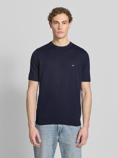 Męski model nosi Regular Fit T-Shirt mit Leinen-Anteil in Strick-Optik von Fynch-Hatton, ciemnoniebieski, mieszanka bawełny i lnu, wyhaftowane logo, elastyczne wykończenia, długość tyłu w rozmiarze M: 70 cm, imitacja dzianiny, Ganzkörperansicht von vorne.