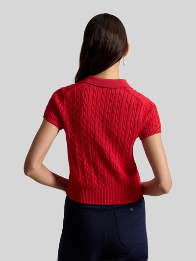 Frauenmodel trägt Regular Fit Strick-Poloshirt aus reiner Baumwolle von Polo Ralph Lauren, Optik: Unifarben, Zopfmuster, Label-Stitching-Applikation, Polokragen, Kurzarm, Ärmelabschluss und Rumpfabschluss: Gerippt, Materialverarbeitung: Strick, Ganzkörperansicht Rückansicht.
