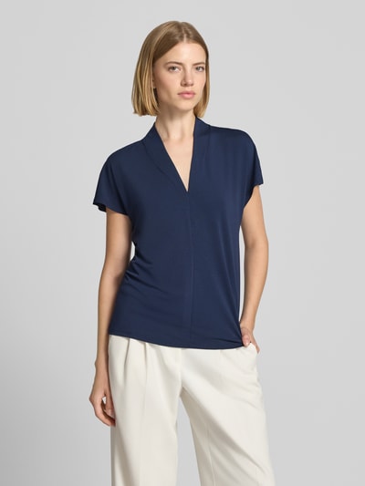 Frauenmodel trägt Regular Fit Bluse mit V-Ausschnitt Modell 'Yrsa' von FREE/QUENT in Dunkelblau, elastischer Material-Mix, kurzärmelig, Stehkragen, Ganzkörperansicht von vorne.