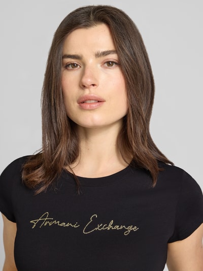 Frauenmodel trägt T-Shirt mit Logo und Rundhalsausschnitt von ARMANI EXCHANGE aus Reine Baumwolle, Slim-Fit, Nahaufnahme Oberkörper.