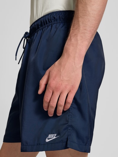 Männermodel trägt Shorts mit Label-Stitching und elastischem Bund von Nike in Dunkelblau, Detailaufnahme seitlich, Regular-Fit, Tunnelzug, Bundweite 41 cm, Innenbeinlänge 14 cm, Größe M.