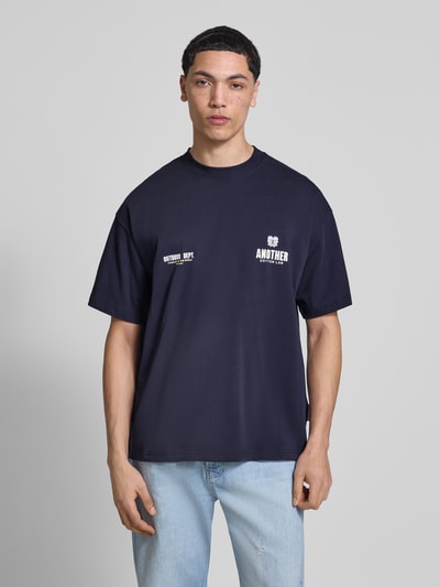 Männermodel trägt Regular Fit T-Shirt mit Logo-Print von ANOTHER COTTON LAB, reine Baumwolle, dunkelblau, Ganzkörperansicht von vorne.