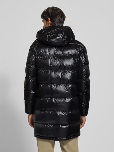 Männermodel trägt Steppjacke mit Kapuze und Eingrifftaschen Modell 'ALDRICH' von Blauer USA in glänzendem Schwarz, Ganzkörperansicht Rückansicht.
