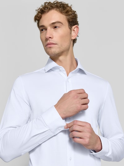 Männermodel trägt Slim Fit Businesshemd mit Strukturmuster von Seidensticker in Weiß, glatte Textur, Nahaufnahme Oberkörper, Herren Businesshemd von Seidensticker.