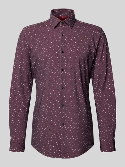 Männermodel trägt Slim Fit Businesshemd mit Kentkragen Modell 'KENNO' von HUGO in Bordeaux mit Optik:Allover-Muster, Ganzkörperansicht von vorne.
