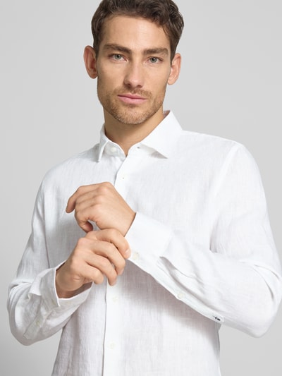 Männermodel trägt Slim Fit Business-Hemd aus linnen met kentkraag van SEIDENSTICKER, knoopsluiting, ruglengte 69 cm, schouderbreedte 43 cm, mouwlengte 64 cm, wit, structuur zichtbaar, nahaufnahme oberkörper.