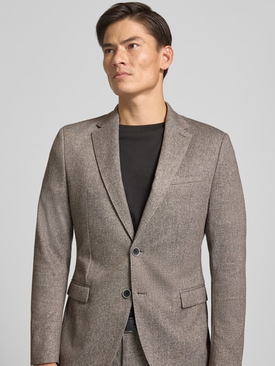 Männermodel trägt Regular Fit Sakko mit Lyocell-Baumwoll-Anteil Modell 'Jogg' von s.Oliver BLACK LABEL in Braun-Grau, Nahaufnahme Oberkörper.