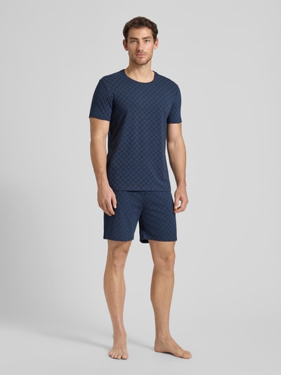 Männermodel trägt T-Shirt mit Logo-Muster und Rundhalsausschnitt von JOOP! Collection aus Baumwoll-Elasthan-Mix in Regular-Fit, Ganzkörperansicht von vorne. Rückenlänge bei Größe M: 68 cm.